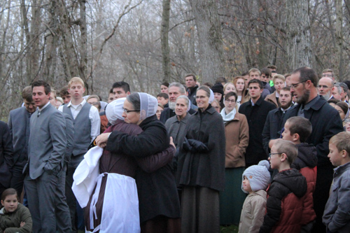 A mother hugs her newly baptized daughter as the crowd of surrounding church members sing.