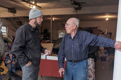 A middle-aged and an elderly man carry on a conversation.
